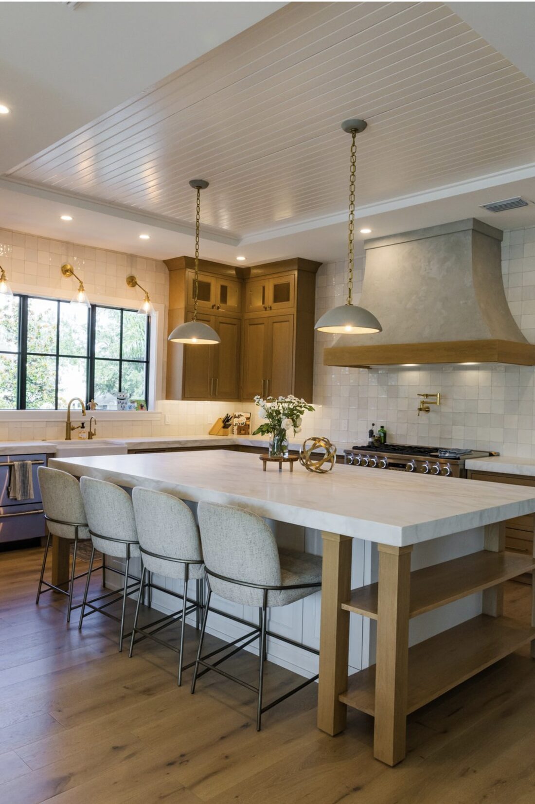 Custom chef's kitchen with marble island, wood cabinetry, and plaster range hood in a South Tampa home by Ejt Legacy Homes