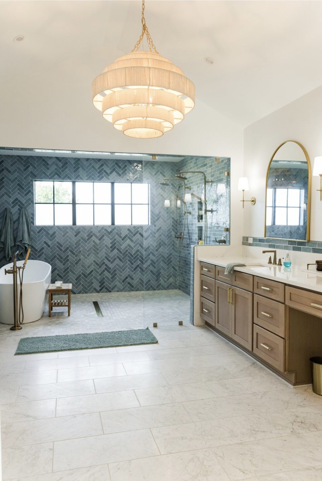Primary bathroom with freestanding soaking tub, blue herringbone tile, and double vanity in a South Tampa custom home by Ejt Legacy Homes